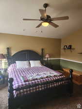 Carpeted bedroom featuring a ceiling fan and vaulted ceiling