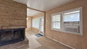 Entryway with baseboards, a fireplace, cooling unit, and tile patterned floors
