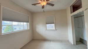 Spare room featuring baseboards, visible vents, ceiling fan, and a textured ceiling