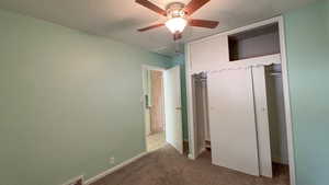 Unfurnished bedroom featuring baseboards, a closet, carpet, and a ceiling fan