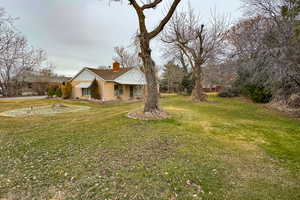 View of front facade with a chimney and a front lawn