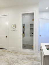 Primary bathroom walk-in shower with marble tile surround