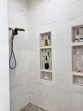 Primary bathroom walk-in shower with marble tile surround