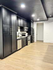Kitchen featuring light countertops, light wood-type flooring, stainless steel appliances including dishwasher.