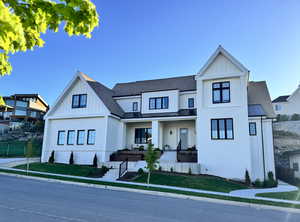 Modern farmhouse style home with board and batten siding, a standing seam roof, and roof with shingles