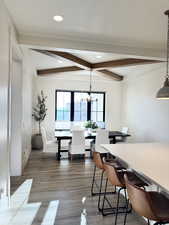 Dining space with a notable chandelier, beamed ceiling, and recessed lighting