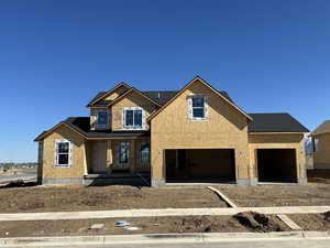 Unfinished property featuring a garage and a porch