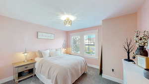 Bedroom featuring carpet and baseboards