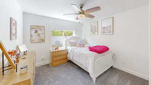 Bedroom with baseboards, carpet floors, and a ceiling fan