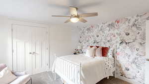 Carpeted bedroom with baseboards, wallpapered walls, a closet, and ceiling fan