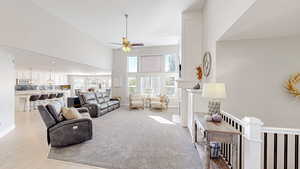 Living area with baseboards, high vaulted ceiling, ceiling fan, and recessed lighting