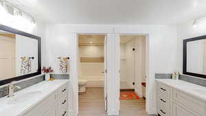 Bathroom with a shower, a sink, two vanities, a textured ceiling, and a bath