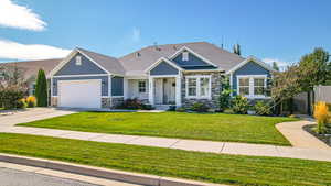 View of front of property with fence, an attached garage, stone siding, and concrete driveway