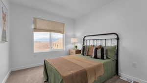 Bedroom with baseboards, visible vents, and carpet
