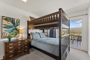 Carpeted bedroom featuring baseboards, access to outside, and a mountain view