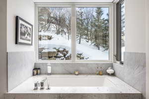 Full bath with a garden tub and backsplash