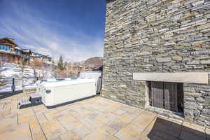 View of patio featuring a fireplace and a hot tub
