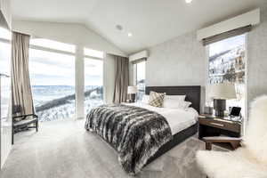 Bedroom with vaulted ceiling, multiple windows, an AC wall unit, recessed lighting, and a mountain view