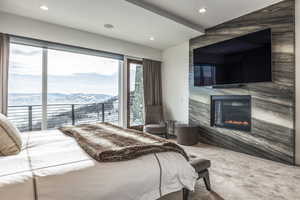 Bedroom with recessed lighting, a fireplace, vaulted ceiling, and carpet flooring