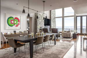 Dining area with healthy amount of natural light, wood finished floors, and expansive windows