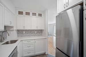 Remodeled kitchen with quartz countertops, white cabinets, and new appliances with stainless steel finishes