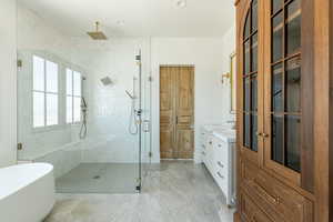 Bathroom with vanity, a freestanding tub, and a shower stall