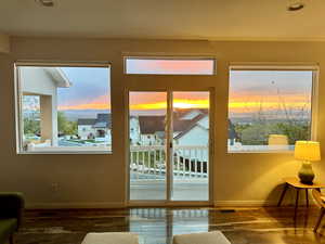 Doorway to outside featuring baseboards, wood finished floors, and a healthy amount of sunlight