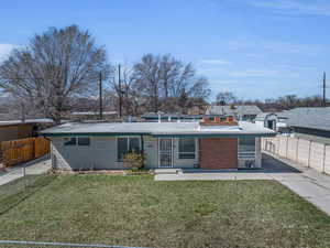 Back of property featuring fence and a yard