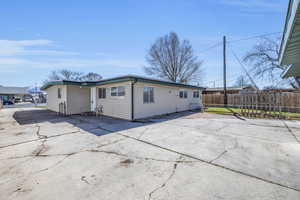 Back of house featuring driveway and fence