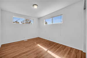 Spare room with visible vents, baseboards, and light wood-type flooring