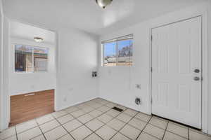 Entryway featuring baseboards, visible vents, and light tile patterned floors