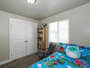 Bedroom with a closet, carpet floors, and a textured ceiling