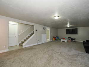 Interior space featuring stairs, a textured ceiling, and carpet