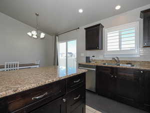 Kitchen featuring plenty of natural light, a sink, dishwasher, and an inviting chandelier