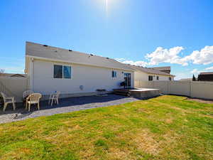 Rear view of property featuring fence private yard, a yard, and a patio