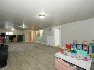 Playroom featuring baseboards, carpet floors, and a textured ceiling