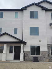 Back of house with central air condition unit and stone siding