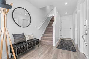 Entrance foyer featuring recessed lighting, baseboards, stairs, and wood finished floors