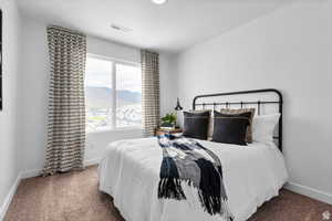 Carpeted bedroom with baseboards, a mountain view, and visible vents