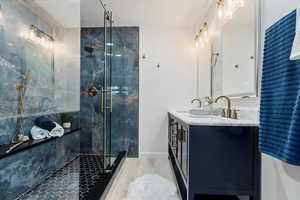 Full bathroom with full wall tile in shower, 3 heads, hand held head and bench with sliding door