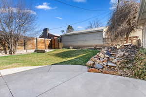 View of yard with fence and a patio area