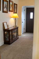 Hallway with carpet floors, arched walkways, and baseboards