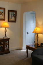 Living area featuring baseboards and carpet