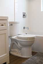 Bathroom with wood finished floors and washtub / shower combination