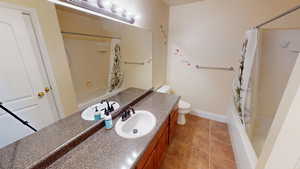 Bathroom with vanity, shower / tub combo with curtain, and tile patterned flooring