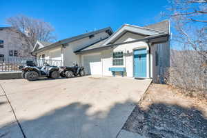 View of front of home featuring driveway, stucco siding, roof with shingles, and an attached garage