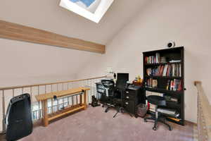 Office with carpet, high vaulted ceiling, a skylight, and beamed ceiling