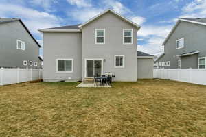 Rear view of property featuring a fenced backyard, stucco siding, a yard, and a patio area