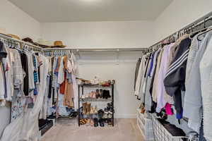 Spacious primary closet with carpet