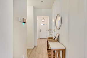 Hallway with baseboards and light wood-style floors